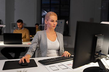 Image showing designer working on computer at night office