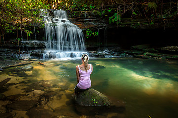 Image showing Woman enjoying nature. Dappled sunlight at the waterfall rock pool