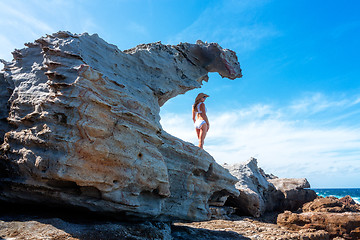 Image showing Woman standing in a sandstone formation by the ocean