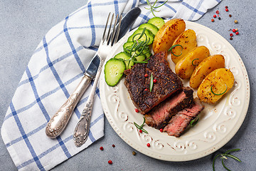 Image showing Steak with pink pepper, rosemary and baked potatoes.