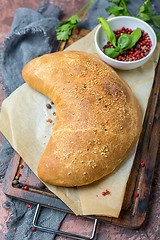 Image showing Traditional pizza calzone on a wooden board.