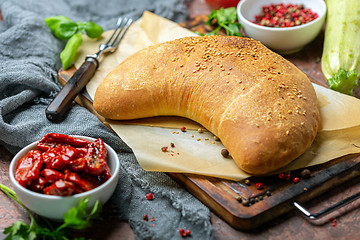 Image showing Homemade pizza calzone on a wooden board.