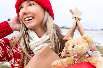 Image showing Festive woman carring Christmas things... Christmas snowy backdrop