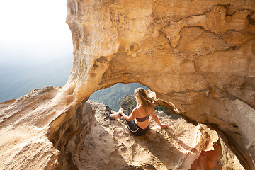 Image showing Female adventurer takes in cliff top cave views Blue Mountains