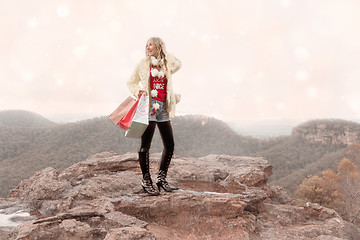 Image showing Female holding shopping bags a wintry scene Christmas in the mountains