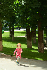 Image showing Happy cute little girl running in the park. Happiness.