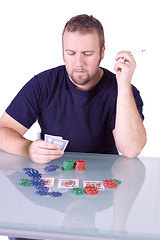 Image showing Man with an Empty Whiskey Bottle on a Poker Table