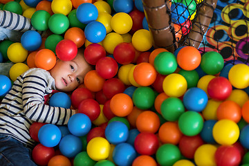 Image showing boy having fun in pool with colorful balls