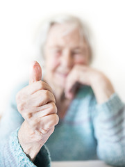 Image showing Happy 96 years old elderly woman giving a thumb up and looking at camera.