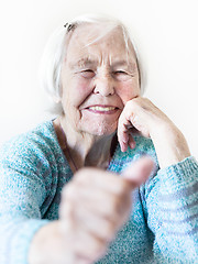 Image showing Happy 96 years old elderly woman giving a thumb up and looking at camera.