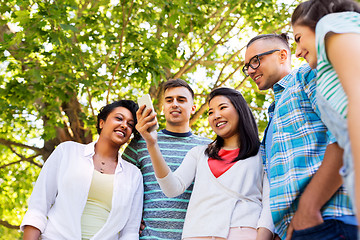 Image showing happy friends with smartphone at summer park