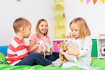 Image showing happy children playing with soft toys at home