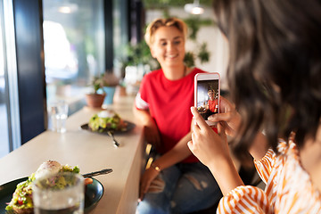 Image showing women having lunch and photographing at cafe