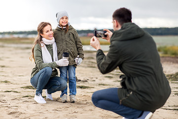 Image showing family photographing by smartphone on autumn beach