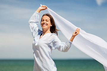 Image showing happy woman with shawl waving in wind on beach