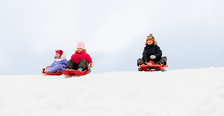 Image showing kids sliding on sleds down snow hill in winter