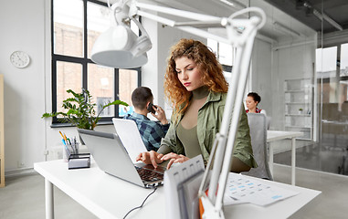 Image showing creative woman with laptop working at office