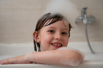 Image showing little girl in bath playing with foam