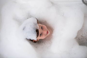 Image showing top view of little girl in bath playing with foam