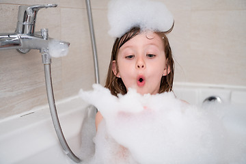 Image showing little girl in bath playing with foam