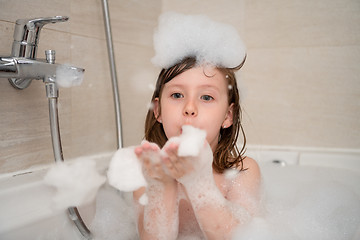 Image showing little girl in bath playing with foam