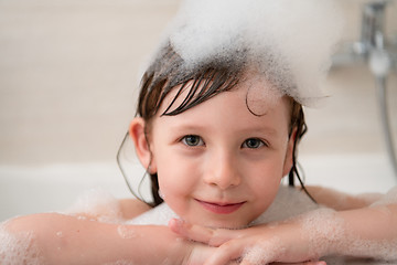 Image showing little girl in bath playing with foam