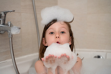 Image showing little girl in bath playing with foam