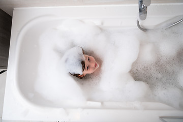 Image showing top view of little girl in bath playing with foam