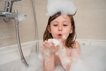 Image showing little girl in bath playing with foam