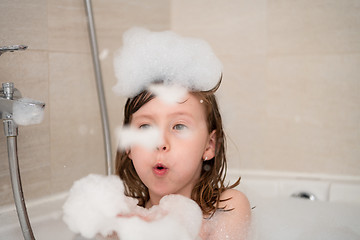 Image showing little girl in bath playing with foam