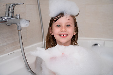 Image showing little girl in bath playing with foam