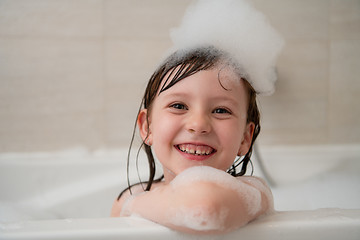 Image showing little girl in bath playing with foam