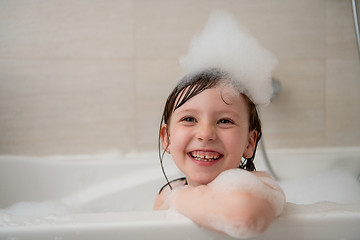 Image showing little girl in bath playing with foam