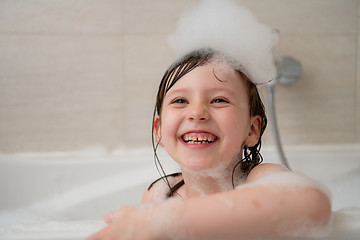 Image showing little girl in bath playing with foam