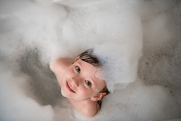 Image showing top view of little girl in bath playing with foam