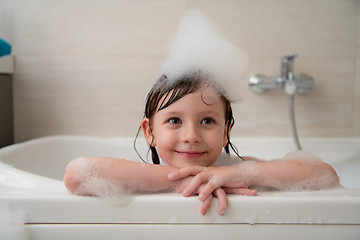 Image showing little girl in bath playing with foam