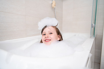 Image showing little girl in bath playing with foam