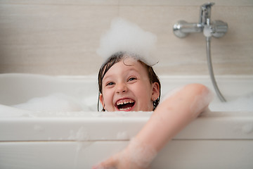 Image showing little girl in bath playing with foam