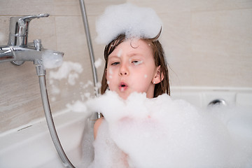 Image showing little girl in bath playing with foam