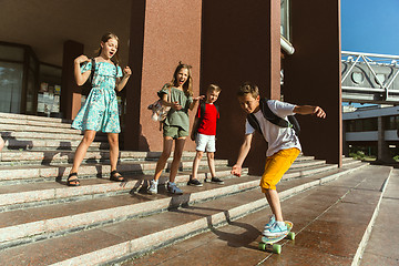 Image showing Happy kids playing at city\'s street in sunny summer\'s day