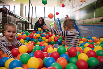 Image showing Young mom with her kids in a children\'s playroom