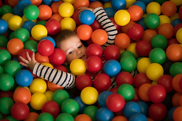 Image showing boy having fun in hundreds of colorful plastic balls
