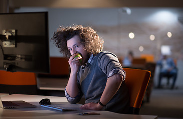 Image showing man eating apple in his office