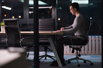 Image showing man working on laptop in dark office