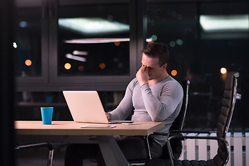 Image showing man working on laptop in dark office