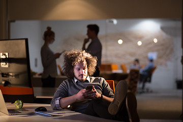 Image showing businessman sitting with legs on desk at office