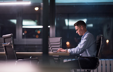 Image showing man working on laptop in dark office