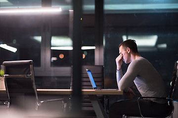 Image showing man working on laptop in dark office