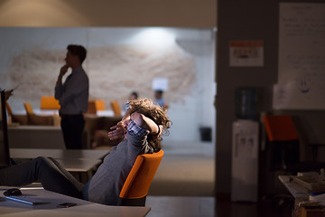 Image showing businessman sitting with legs on desk at office