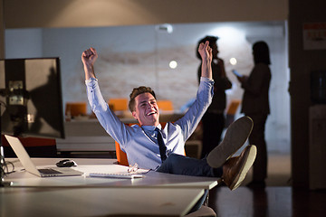 Image showing businessman sitting with legs on desk at office